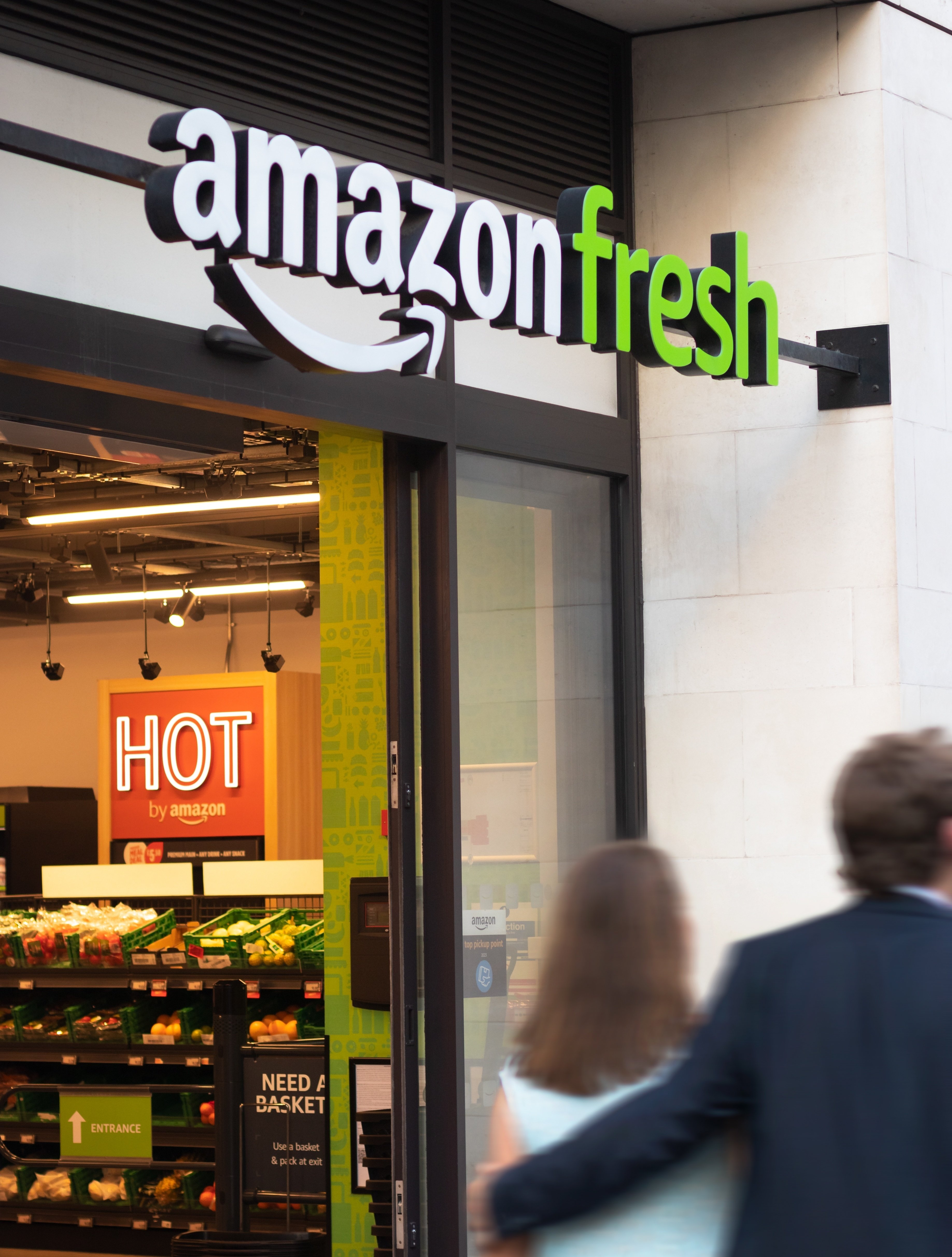 A couple walks past a cashierless Amazon store.