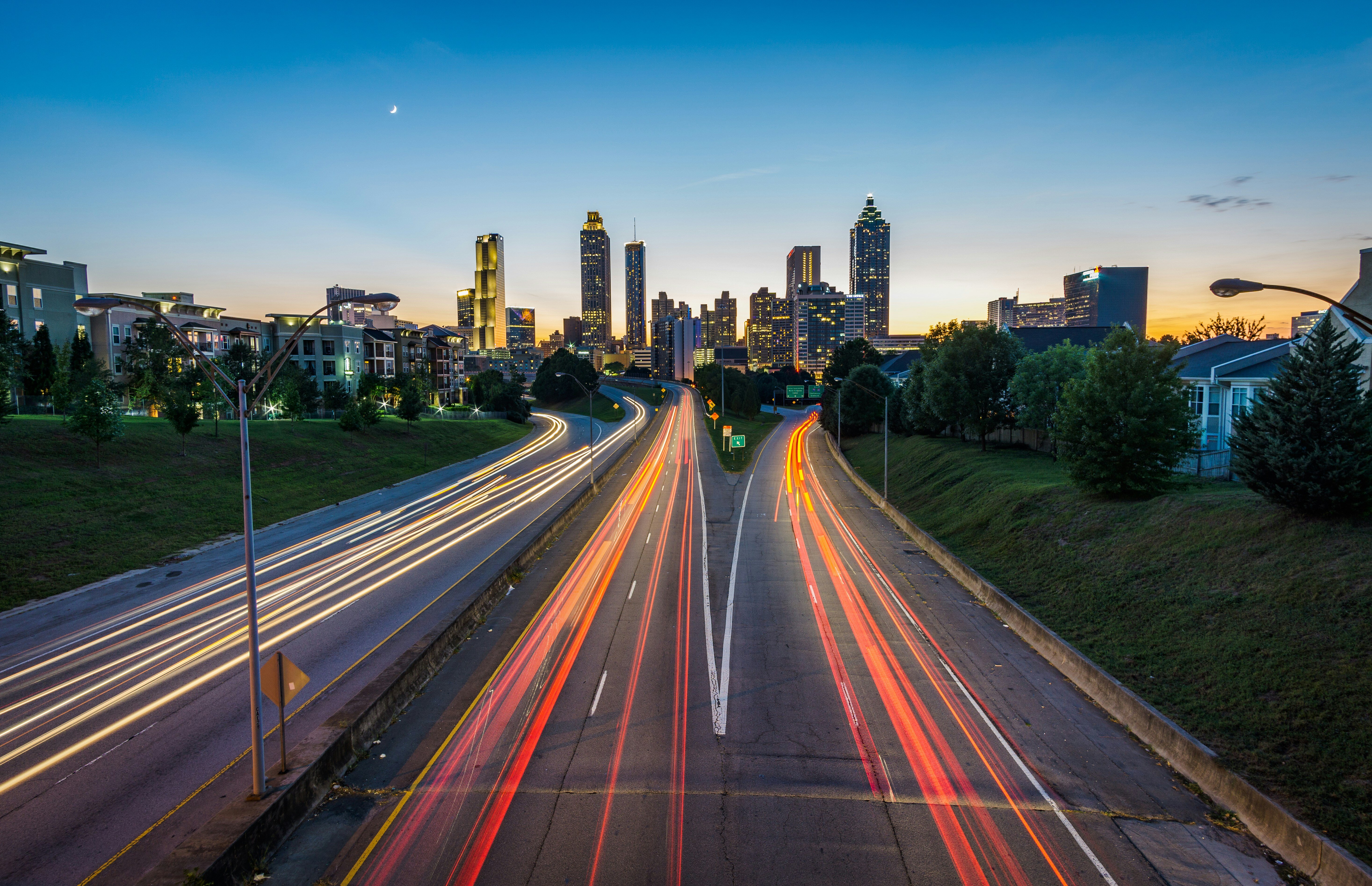 A timelapse shows traffic flowing in and out of a city on a highway.